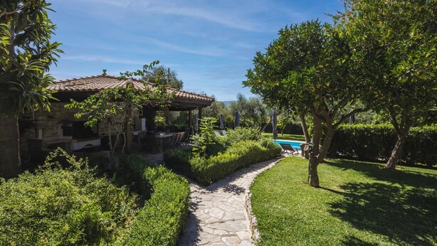 A stone house with a tiled roof, a stone pathway, and a swimming pool. - Villa Lilly with private pool (Zakynthos)