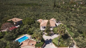 An aerial view of a residential area with two houses, a swimming pool, and a well-maintained garden. - Villa Lilly with private pool (Zakynthos)