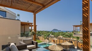 Una terraza en la azotea con mobiliario exterior, piscina y vistas al mar.