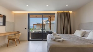 Una habitación de hotel moderna con una cama grande, un escritorio y un balcón con vistas.