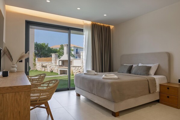 A modern bedroom with a large bed, a desk, and a wicker chair.