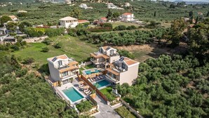 Una villa moderna con piscina, varias habitaciones y un jardín amplio.