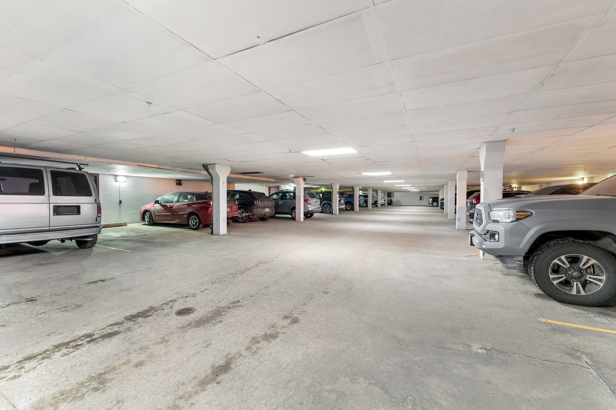 Un parking à plusieurs niveaux, doté de piliers en béton et offrant un environnement propre et bien éclairé.