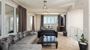 Een moderne woonkamer met een bank, een salontafel en een eetgedeelte met uitzicht.