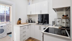 Eine moderne Küche mit weißen Schränken, einem eingebauten Backofen und einem Spülbecken.