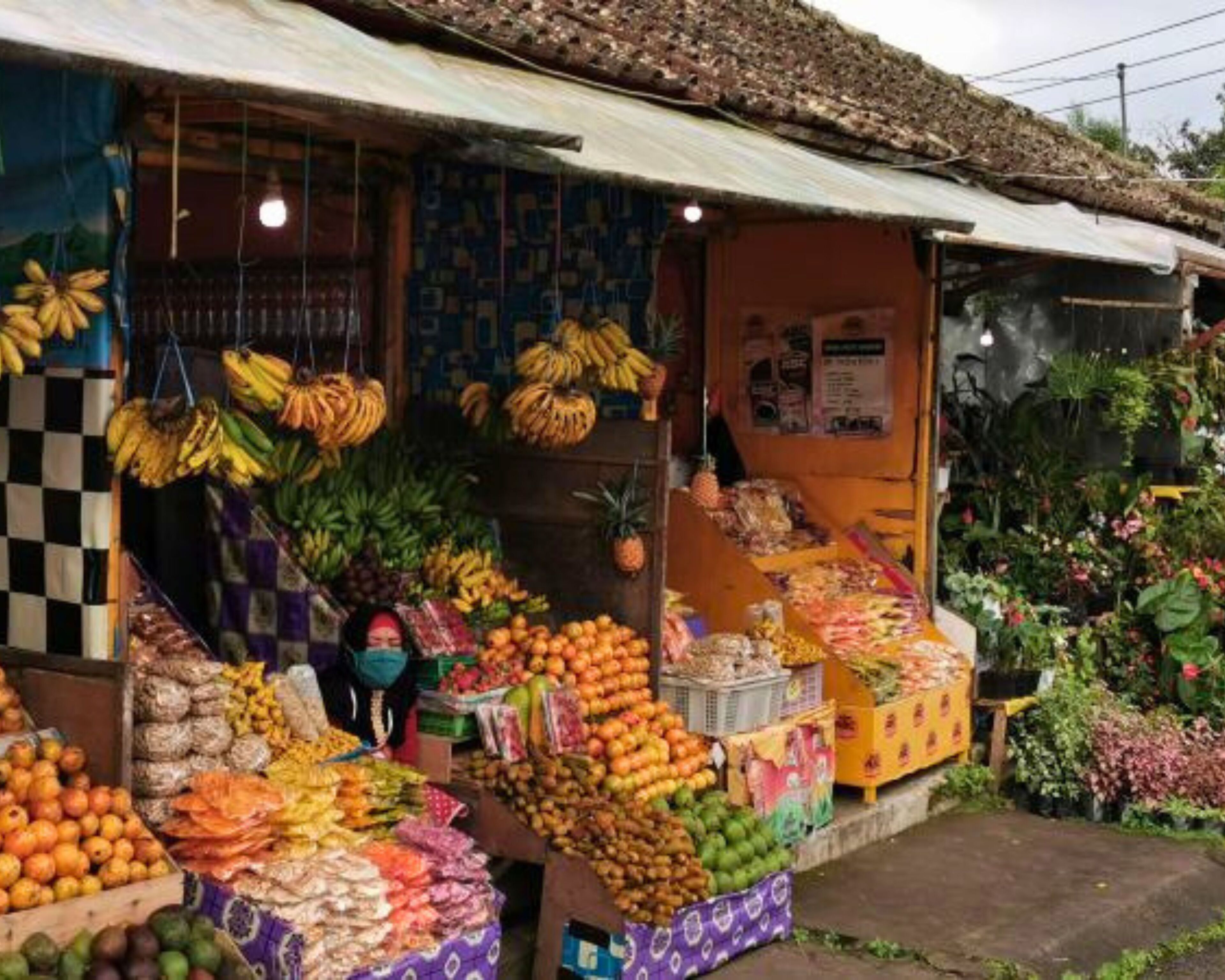 Puesto de mercado con frutas y verduras a la venta.
