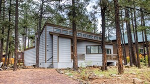 A modern cabin with a sloped roof, large windows, and a deck. - Black Bear Retreat - Wonderful 3 bed cabin in Pinetop with a fenced yard & Wifi. (Pinetop)