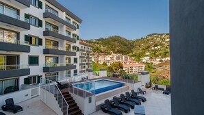 Un edificio moderno con piscina en la azotea y terraza.