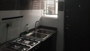 A kitchen with a gas stove, a sink, and a window.