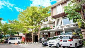 A convention hotel with multiple floors, a covered entrance, and several parked cars. - Andelir Hotel Simpang Lima Semarang  (Semarang)