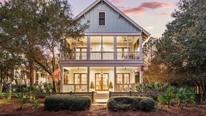 A two-story house with a balcony, surrounded by trees and a well-maintained garden. - WaterColor Beach Retreat Offering a Private Pool, Golf Cart, And Full Access to the Beach Club! (Santa Rosa Beach)