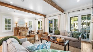 A spacious living room with a wooden ceiling, large windows, and a cozy seating area with a sofa and chairs. - WaterColor Beach Retreat Offering a Private Pool, Golf Cart, And Full Access to the Beach Club! (Santa Rosa Beach)
