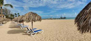 På stranden, solsenger og strandhåndklær