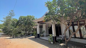 A building with a tiled entrance and potted plants. - DAlvin Homestay: Cozy, Central Labuan Bajo, Near Airport–Perfect for Your Stay! (Kabupaten Labuan Bajo)