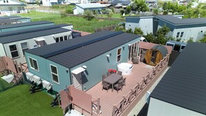 Una zona residenziale con diverse case, una vasca idromassaggio e mobili da esterno su un terrazzo.
