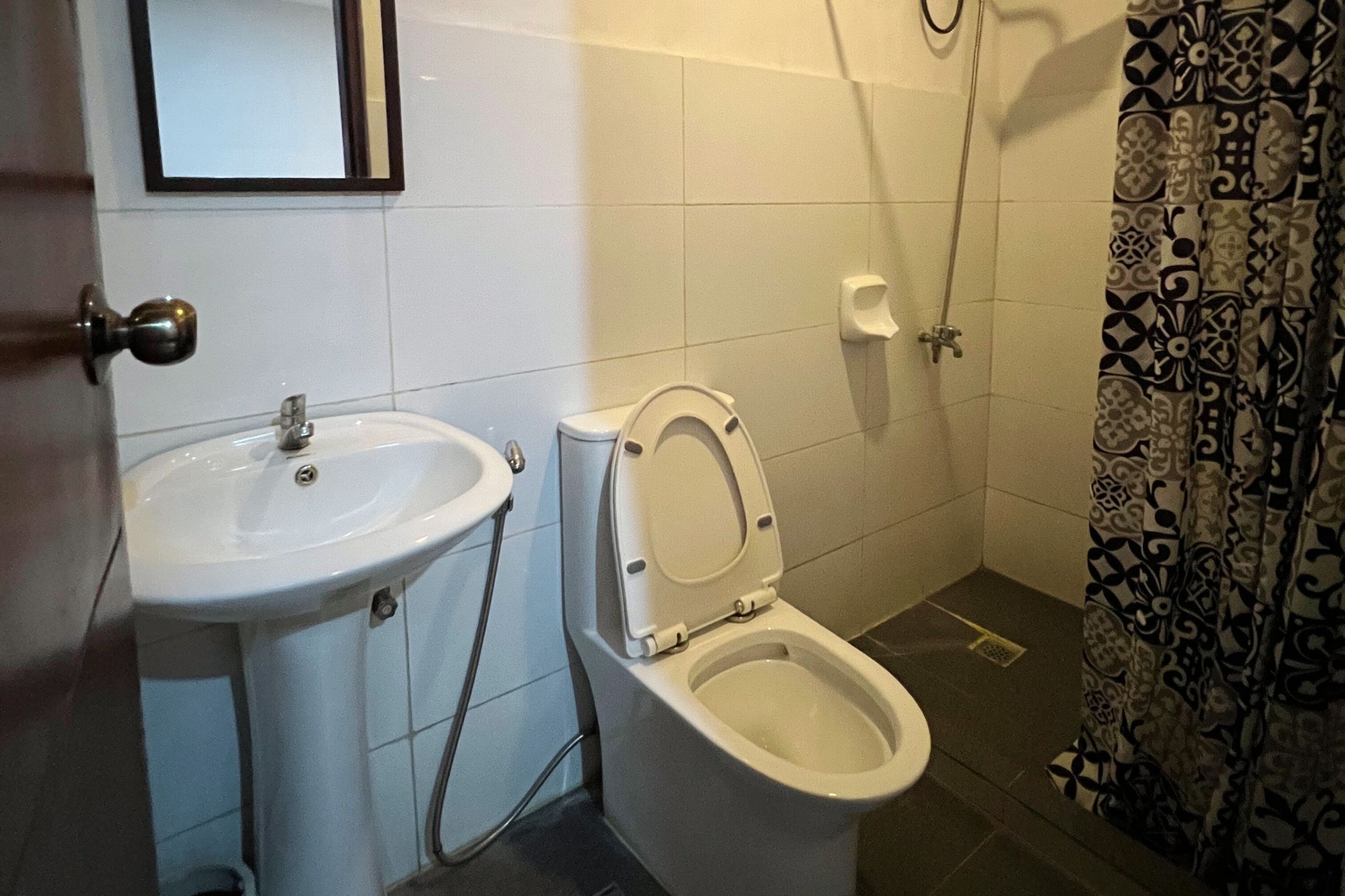 Un baño con lavamanos, inodoro y ducha.