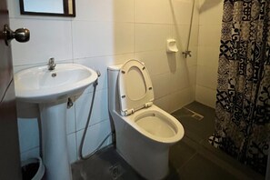 Ein Badezimmer mit Toilette, Waschbecken und Duschvorhang.