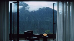 Ein Zimmer mit einer großen Glasdoor, die auf einen Balkon mit Bergblick führt.