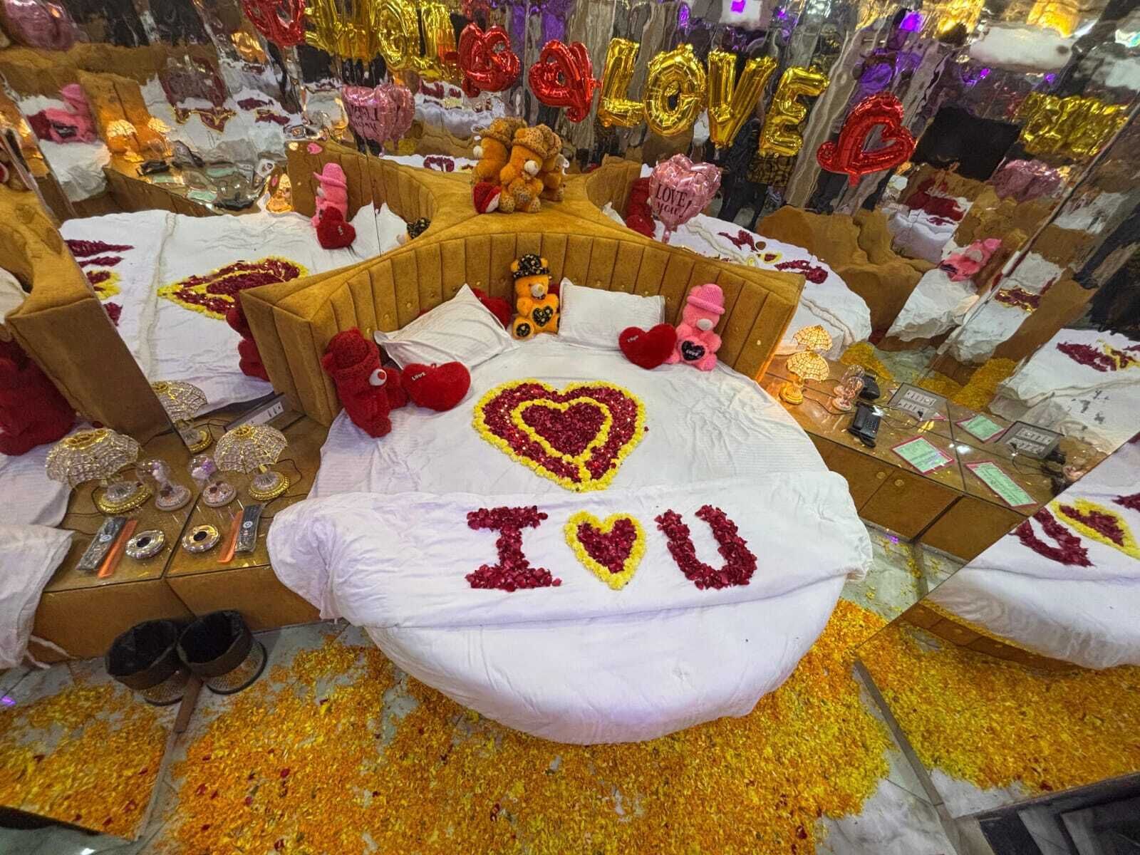 A room with a bed decorated with heart-shaped flower arrangements and the name "Ivu" on the pillow.