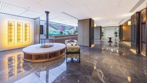 A modern lobby with a central seating area, a fireplace, and a large digital display. - True Go S Hotel Nanshan Nantou (Shenzhen)