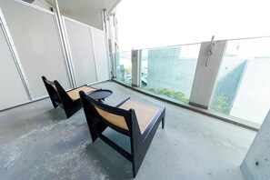 A balcony with two black chairs and a small table, overlooking a cityscape. - RUBY 501 (Otaru)