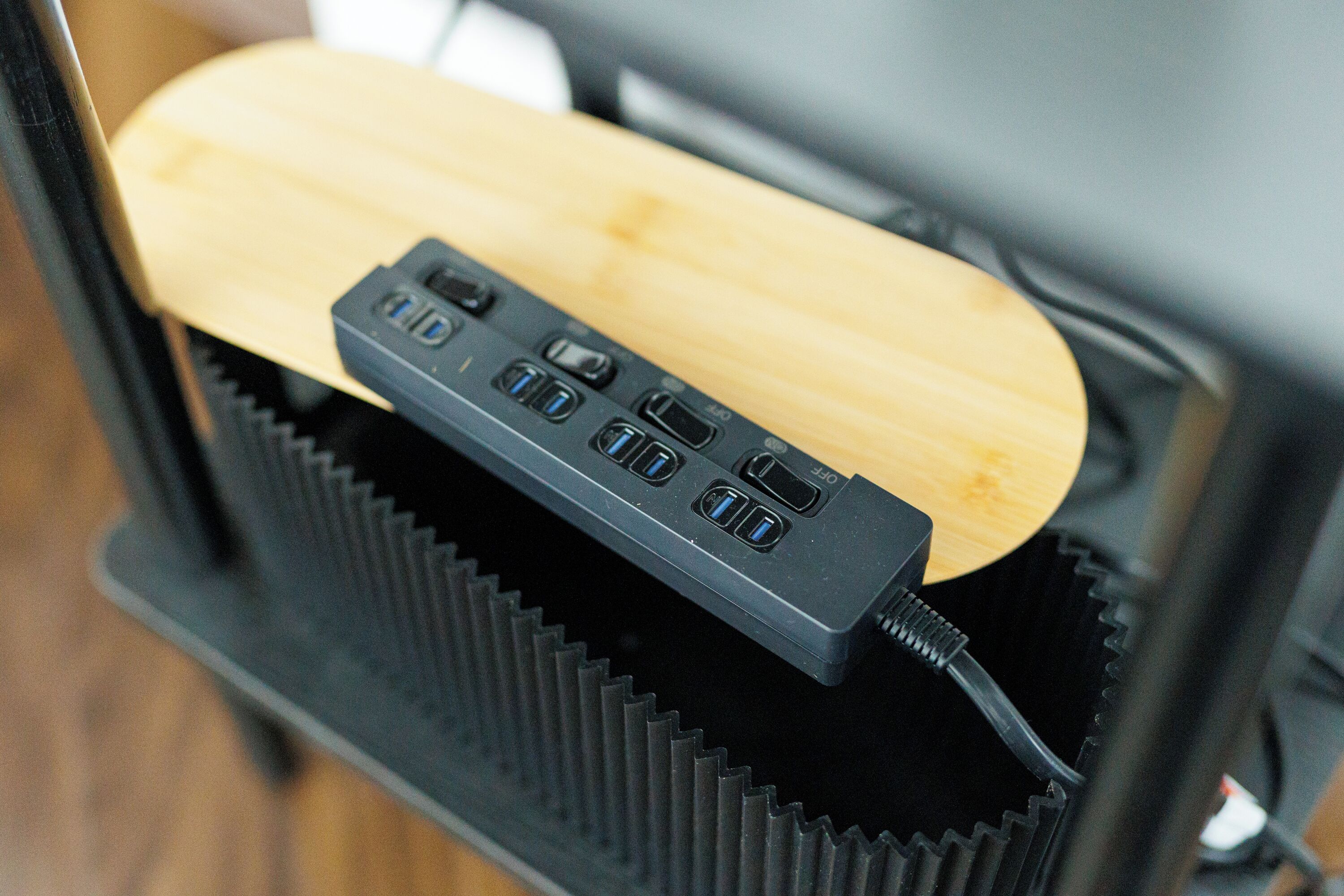 Primer plano de un objeto de madera con un dispositivo electrónico negro adherido.