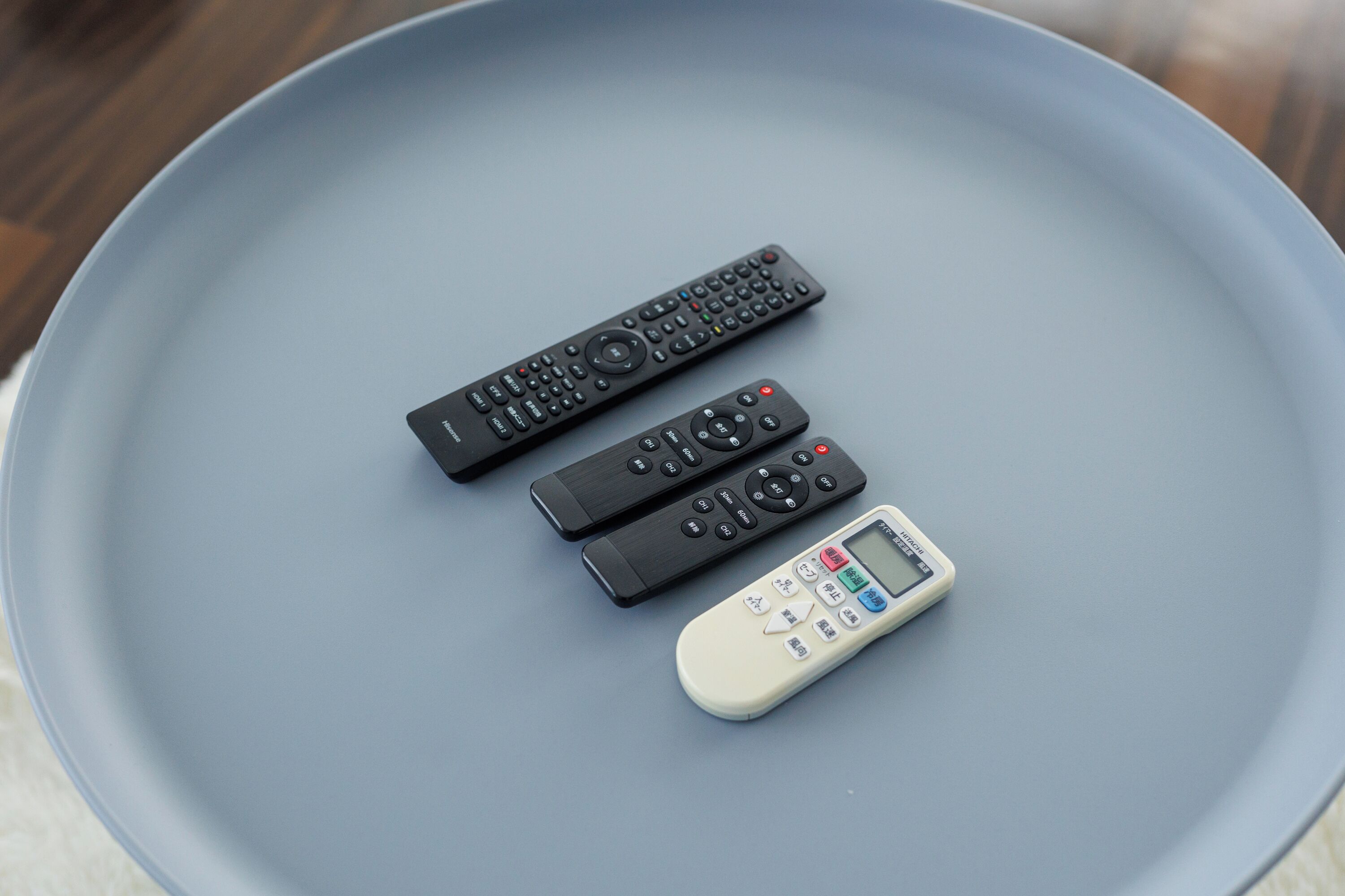 Three remote controls on a light blue tray.