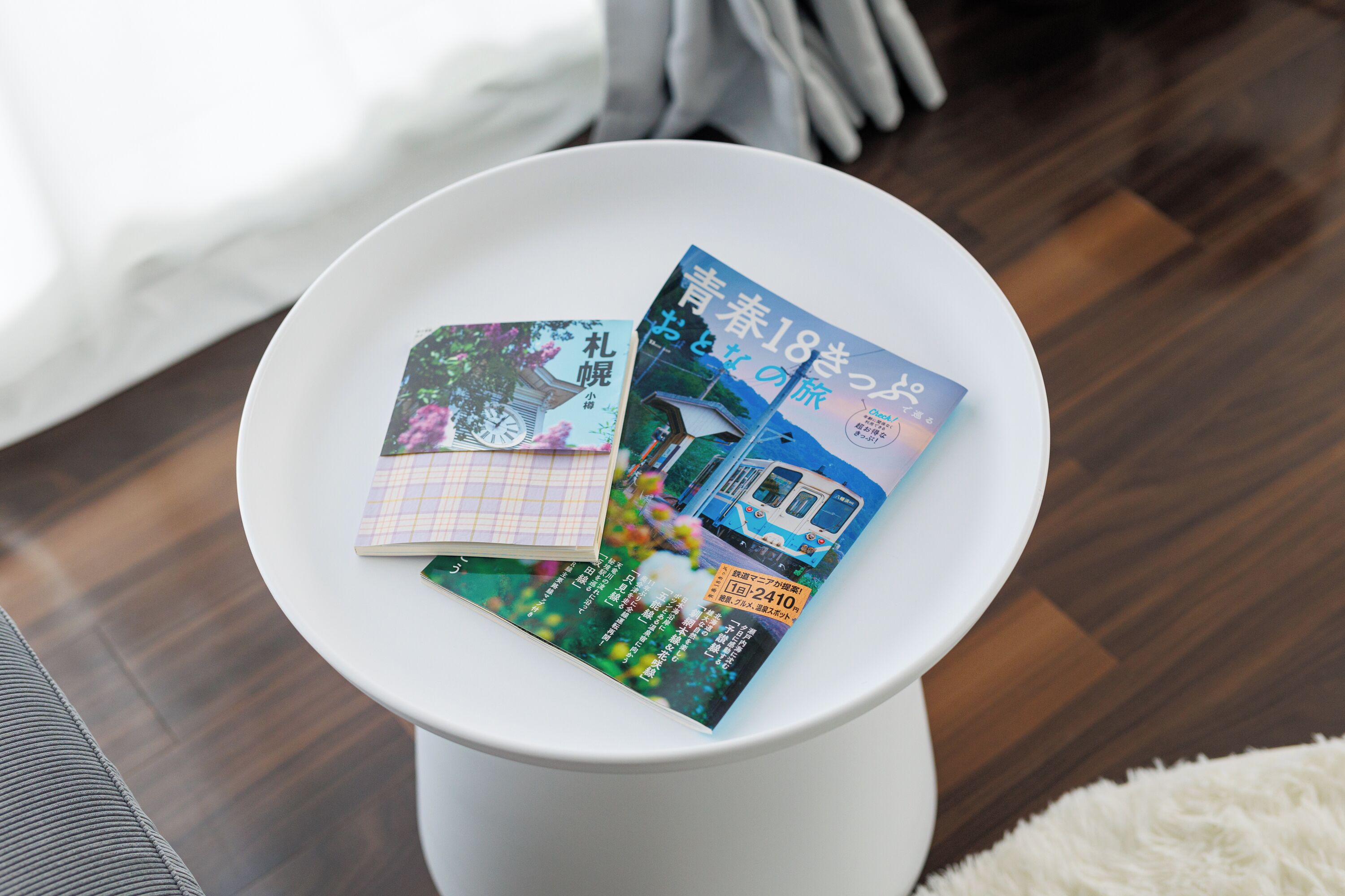 Una mesa blanca con dos revistas encima.