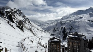 Ein mit Schnee bedeckter Berg mit Seilbahnen und Gebäuden.