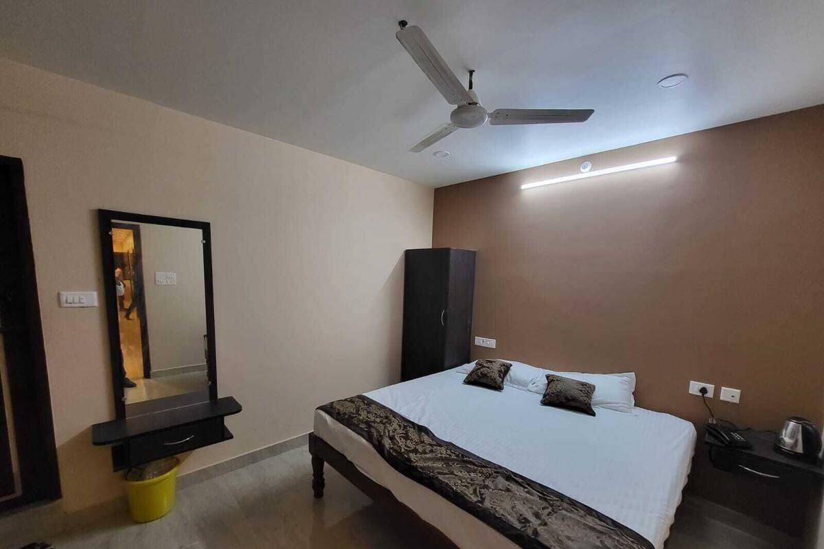 Un dormitorio con cama, ventilador de techo, armario y espejo.
