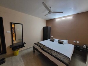 A bedroom with a bed, a ceiling fan, a wardrobe, and a mirror. - Panakal Park Homestay (Villianur)