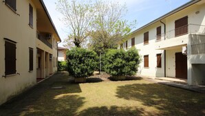 Une cour intérieure avec un chemin, entourée d’immeubles dotés de balcons et de fenêtres.
