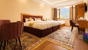 Une chambre d’hôtel avec un grand lit, un bureau, une chaise et un téléviseur.
