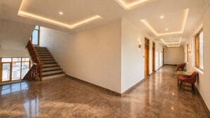 Un hall d’entrée spacieux avec un escalier, un éclairage encastré au plafond et une vue sur l’extérieur.