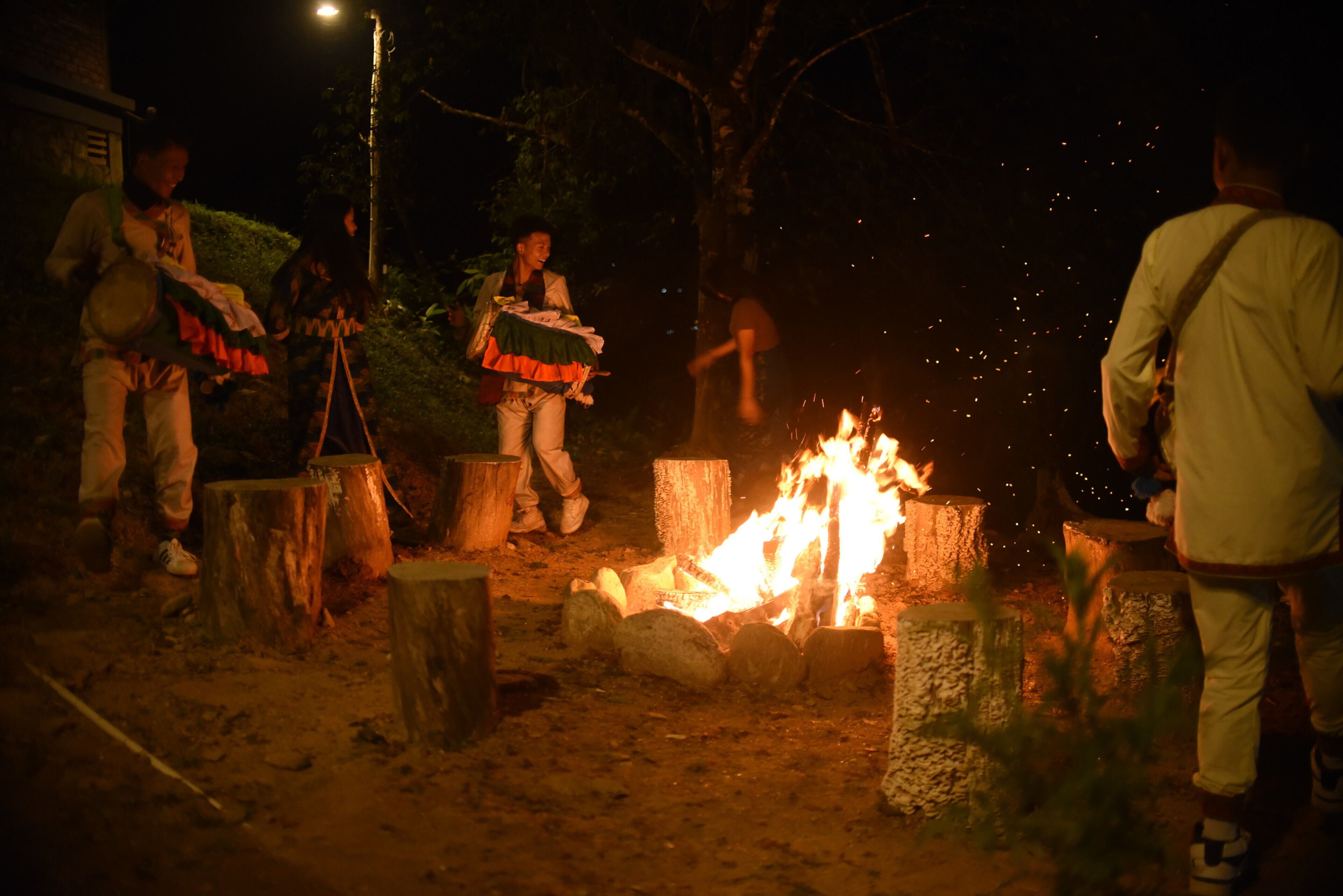 A group of people around a campfire at night.