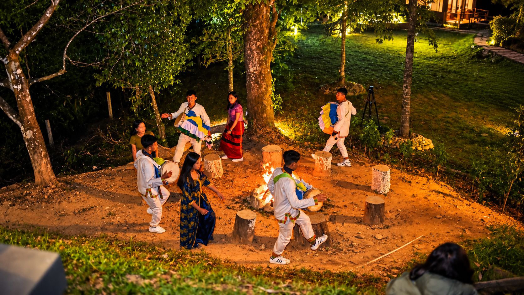A group of people performing a traditional dance outdoors at night.