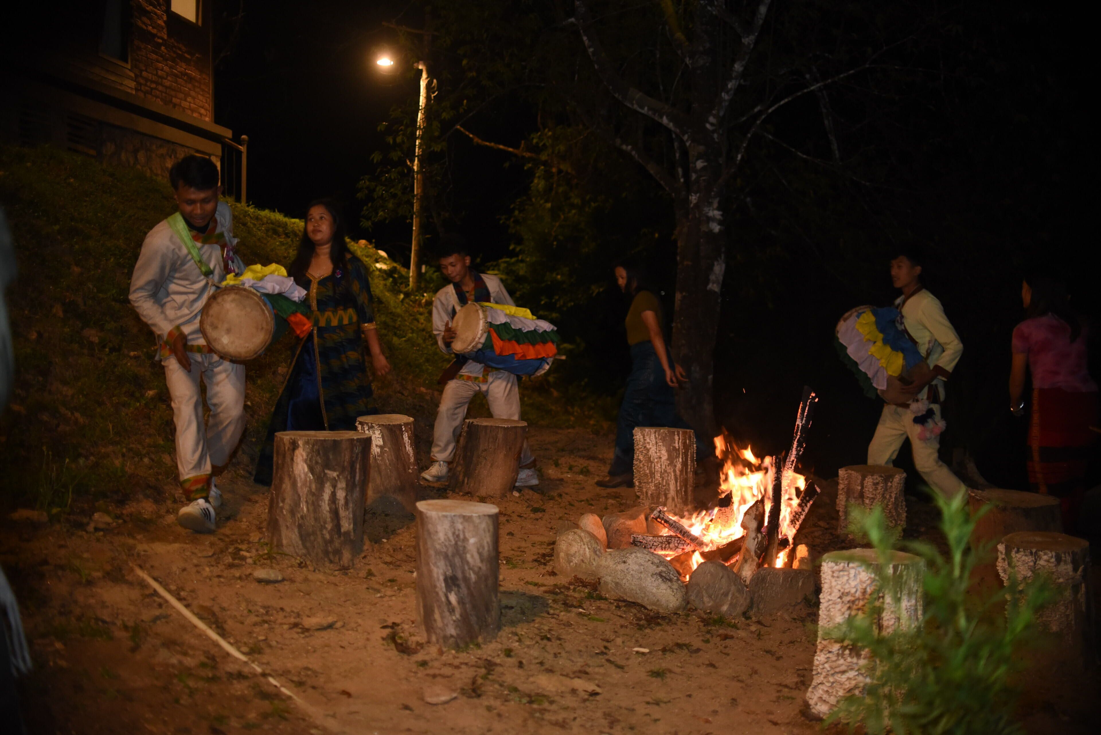 Un grupo de personas tocando la batería al aire libre de noche.