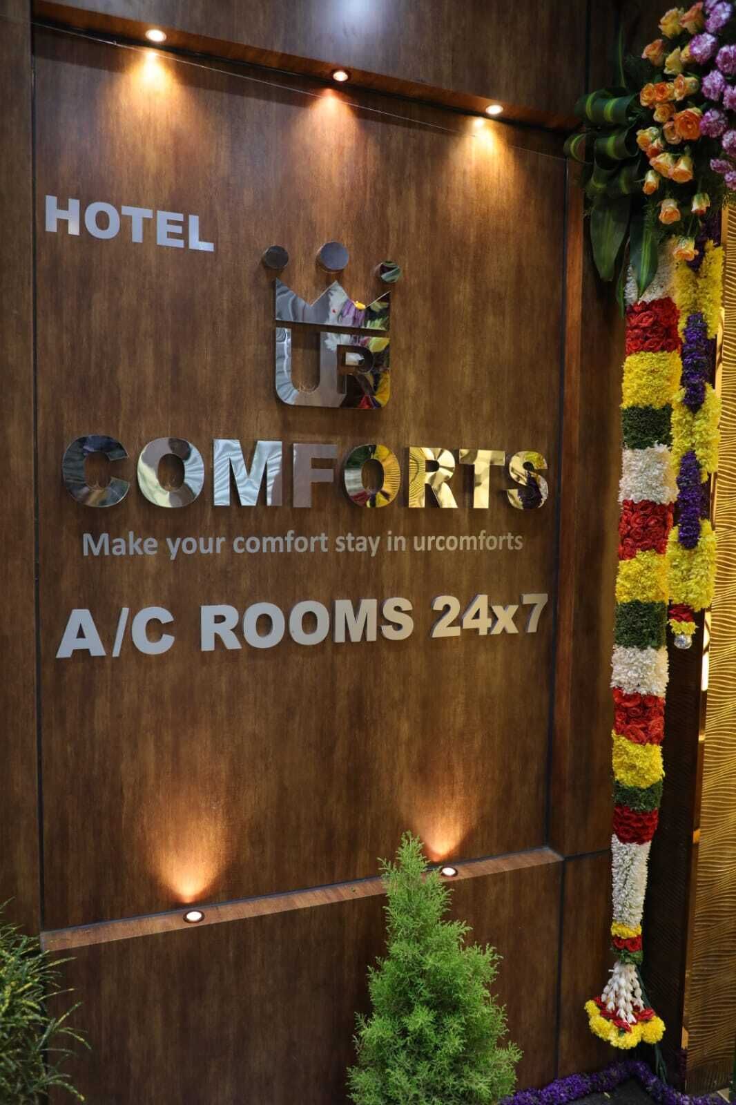 Pared de madera con un letrero que indica 'COMFORTS' y 'HABITACIONES CON A/C 24x7'.