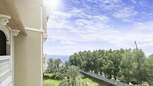 Un balcon donnant sur un jardin luxuriant et verdoyant, avec une étendue d’eau en vue.