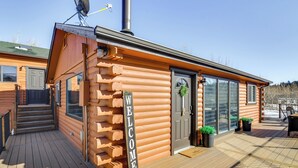A log cabin with a 'WELCOME' sign, a deck, and a door with a wreath. - Mtn-View Haven w/ Hot Tub: 9 Mi to Dtwn Bailey (Bailey)