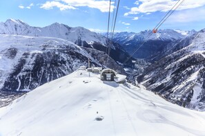 A snow-covered mountain landscape with a ski lift cable and chairlift. - Graceful Apartment In Courmayeur (Courmayeur)