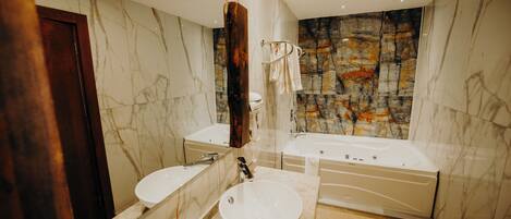 Une salle de bain moderne avec un meuble-lavabo en marbre, un évier, une baignoire et un grand miroir.