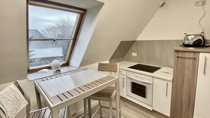 A small kitchen with a window, a table, and a stove.