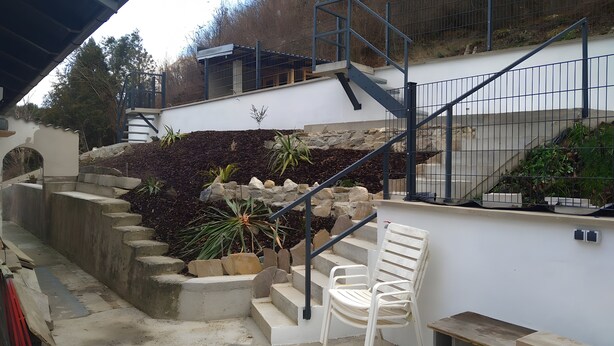 A staircase with a metal railing, a white chair, and a small table. - Holiday Home 'Ferienhaus Kesper' with Mountain View, Private Terrace & Wi-Fi (Schottwien)