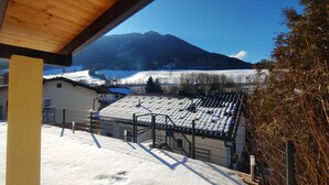 A snowy landscape with a mountain in the background, a building with a sloped roof, and a fenced area. - Holiday Home 'Ferienhaus Kesper' with Mountain View, Private Terrace & Wi-Fi (Schottwien)