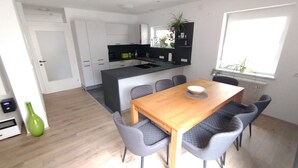 A modern kitchen with white cabinets, a black countertop, and a built-in oven. - Holiday Home 'Ferienhaus Kesper' with Mountain View, Private Terrace & Wi-Fi (Schottwien)