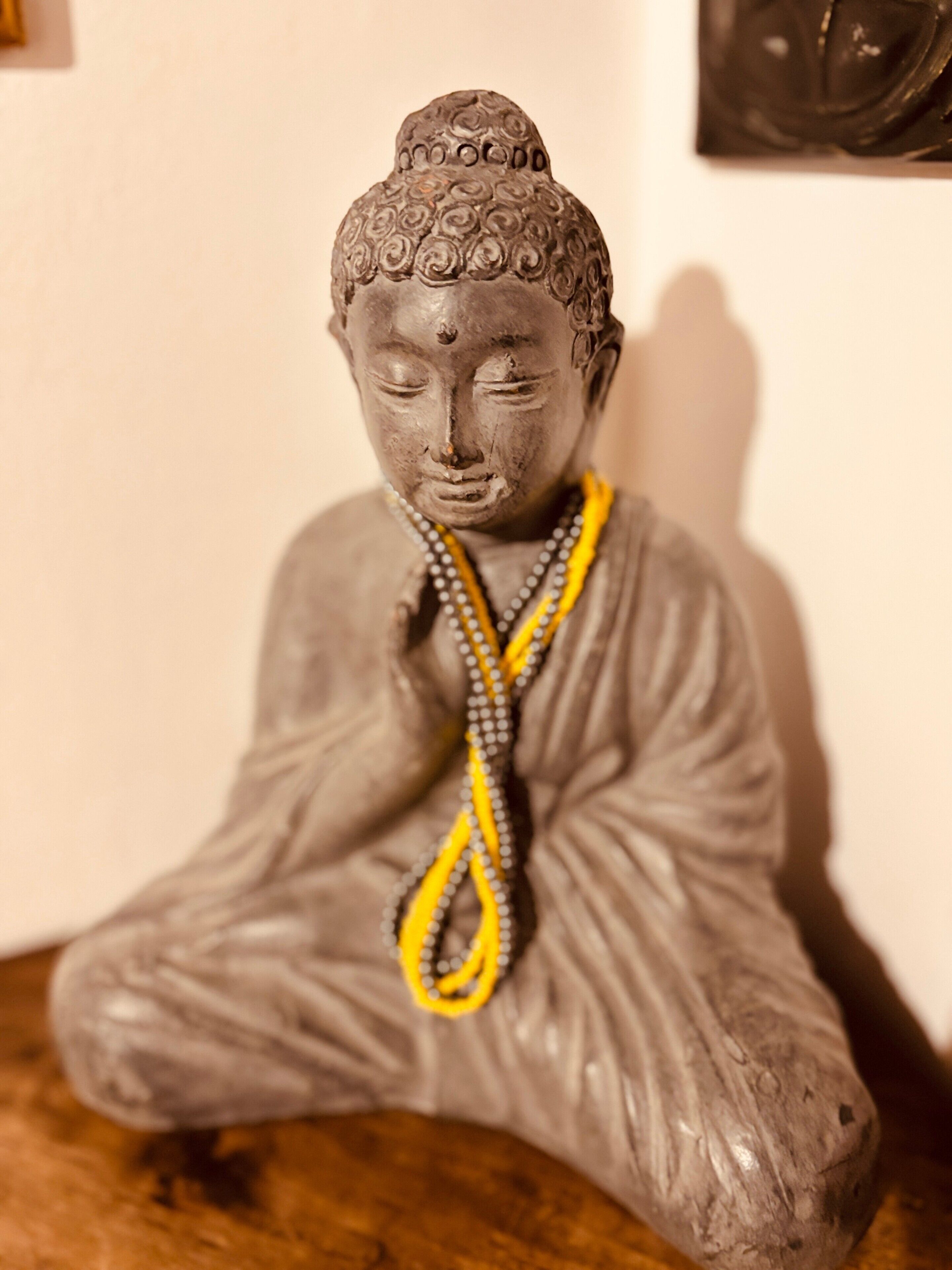 A statue of a seated figure with a textured head and a draped garment.