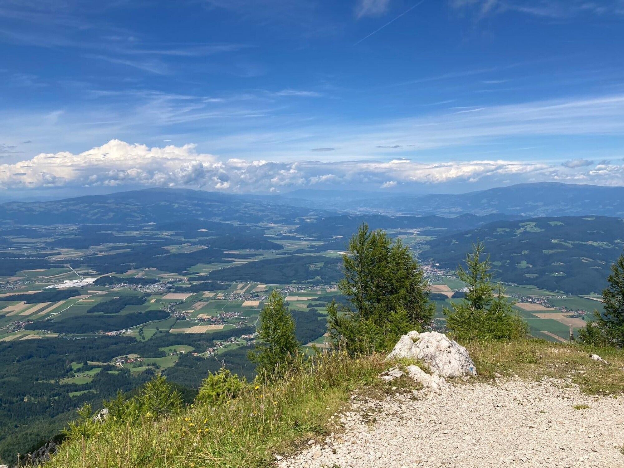 Ein weiter Panoramablick auf eine gebirgige Landschaft bei blauem Himmel.