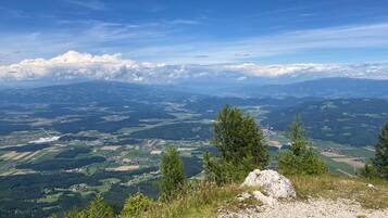 Ein weiter Panoramablick auf eine gebirgige Landschaft bei blauem Himmel.