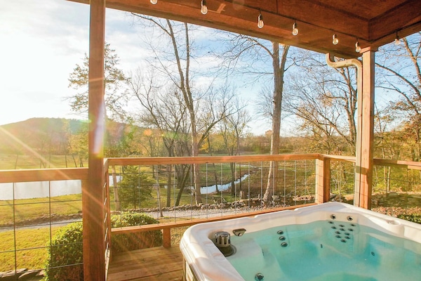 Unwind in the covered hot tub with hillside views—perfect for sunsets & stargazing.